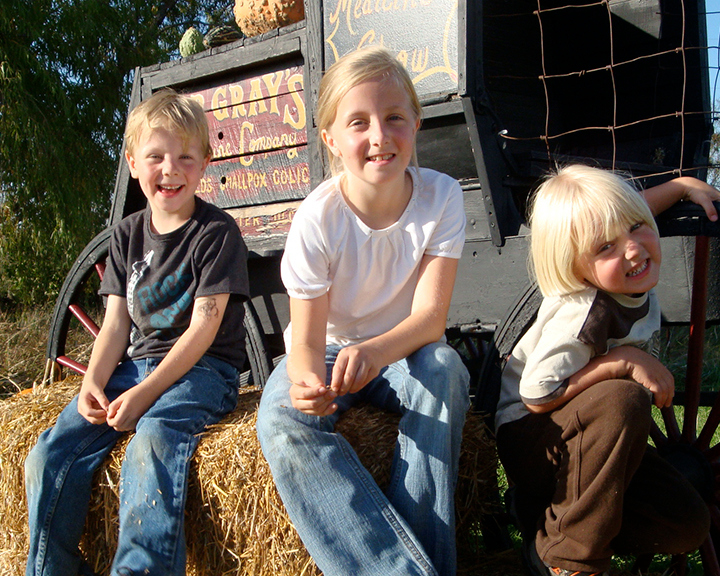Three Harris children on hay bales